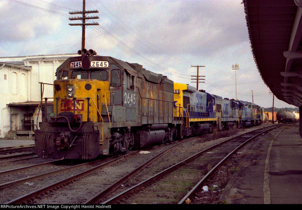 CSX 2645 and other locos are tied down on a train in the yard